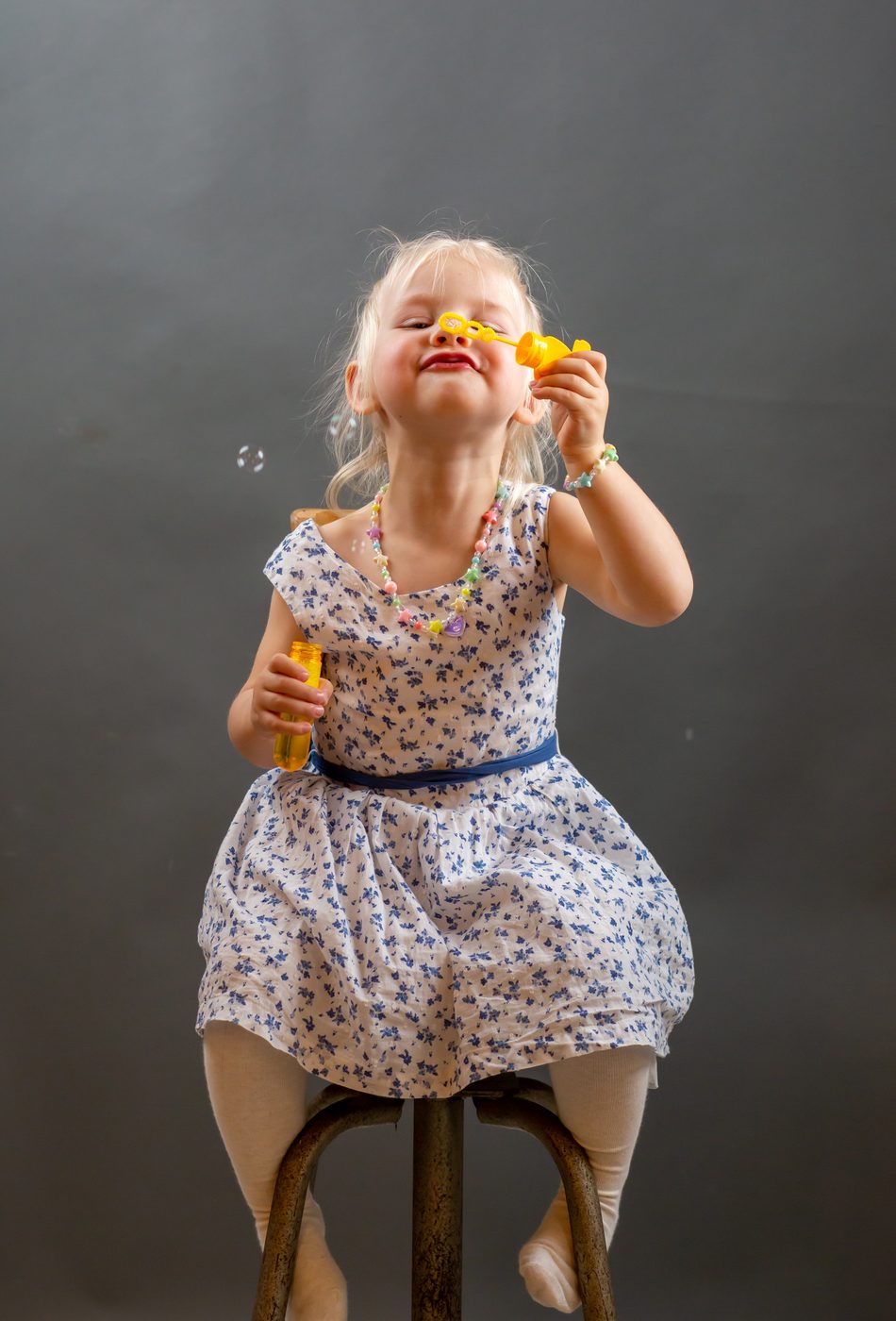 Petite fille faisant des bulles de savon, studio