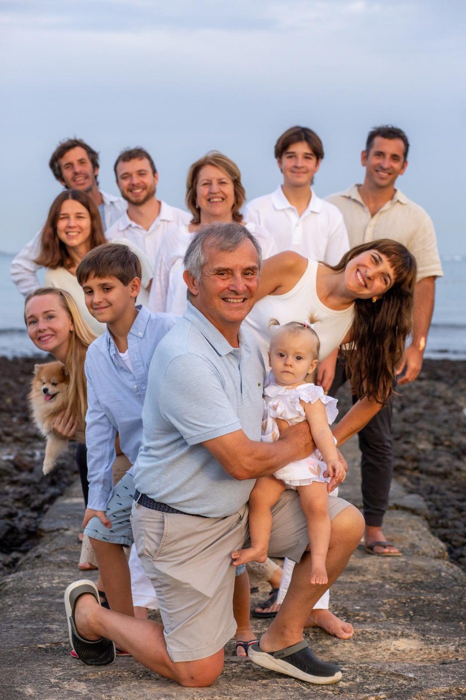 Séance famille au bord de l'eau, grand-père et bébé au premier plan