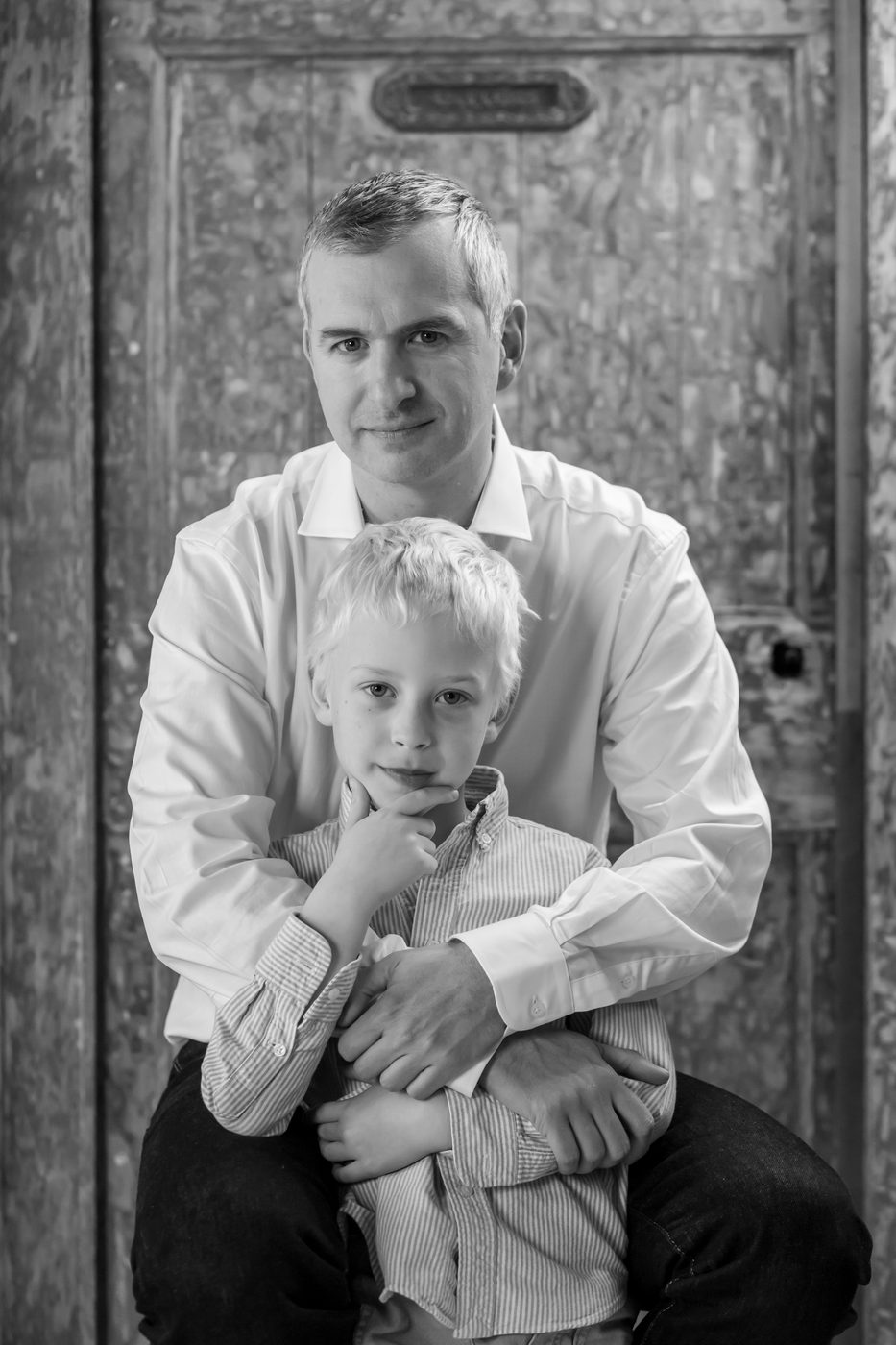 Père et fils devant une porte ancienne, noir et blanc